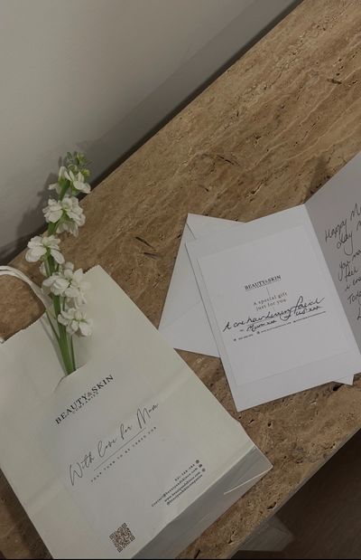 Gift package and greeting card on a marble surface.