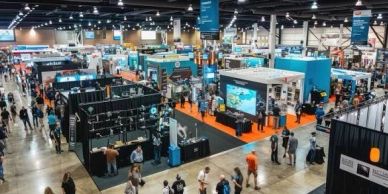 A busy technology expo with multiple booths and attendees.
