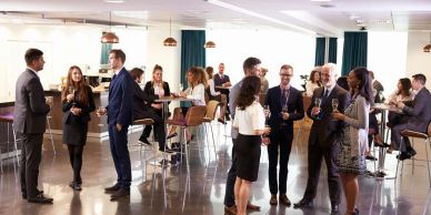 Professionals networking at a corporate event with drinks.