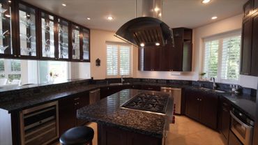 Modern kitchen with dark wood cabinets and granite countertops.