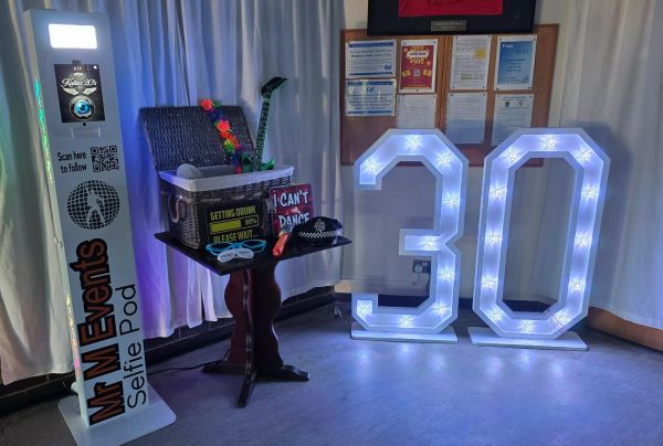 30th birthday light up numbers beside a DJ setup
