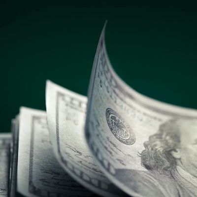 Close-up of fanned US hundred-dollar bills with Benjamin Franklin's portrait.