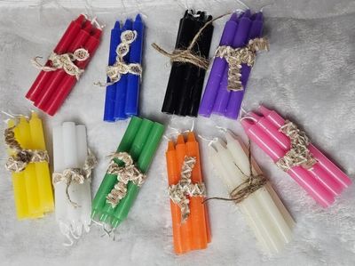 Colorful bundles of candles tied with twine on a soft surface.