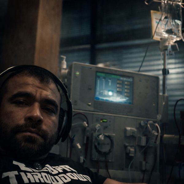 Man undergoing dialysis with headphones on.