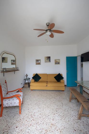 Bright living room with yellow sofa and blue door.