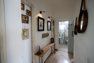 Cozy hallway with butterfly art and rustic wooden decor leading to a bathroom.