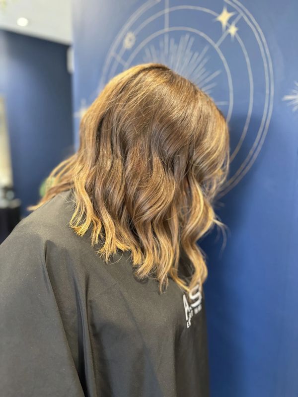 Women with softly curled hair with golden highlights