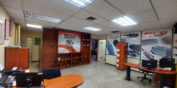 Oficina con escritorios y exhibidores de productos.