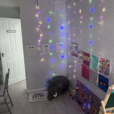 Cozy corner with fairy lights and art in a child's room.