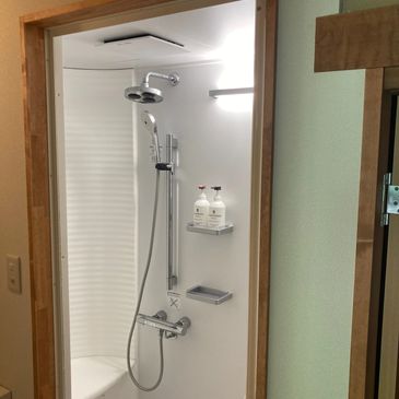Modern shower setup with adjustable showerhead and water heater in a bathroom.