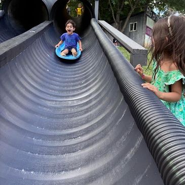Children playing on a large slide at a park.