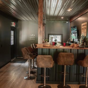 Cozy bar area with rustic decor and high stools.