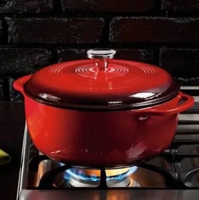 Red pot on a stove with flame.