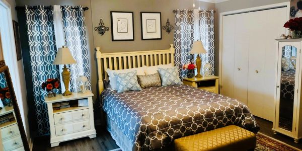 Cozy bedroom with patterned curtains and a wooden bed frame.