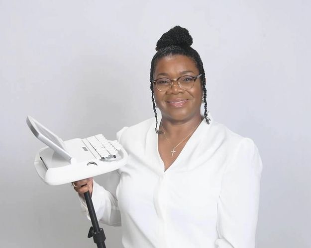 Photo of Angela E. Denmark, RPR, standing up while holding Luminex writer.