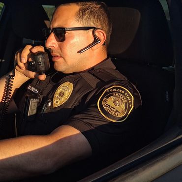 Security officer speaking into a radio inside a vehicle.