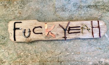 Exuberant agreement, made of scrap metal and crafted letters on driftwood. Versions available at my