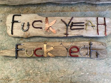 Exuberant agreement, made of scrap metal and crafted letters on driftwood.