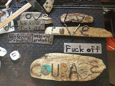 Various signs, some with Lake Ontario driftwood.