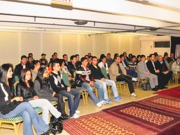 A group of people seated attentively in a conference or seminar room.