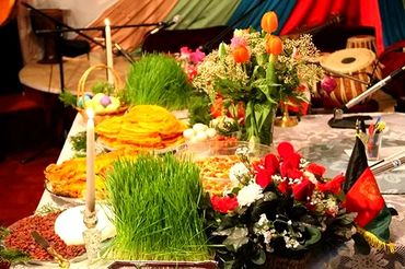 Decorative table with flowers, candles, and traditional food for a celebration.