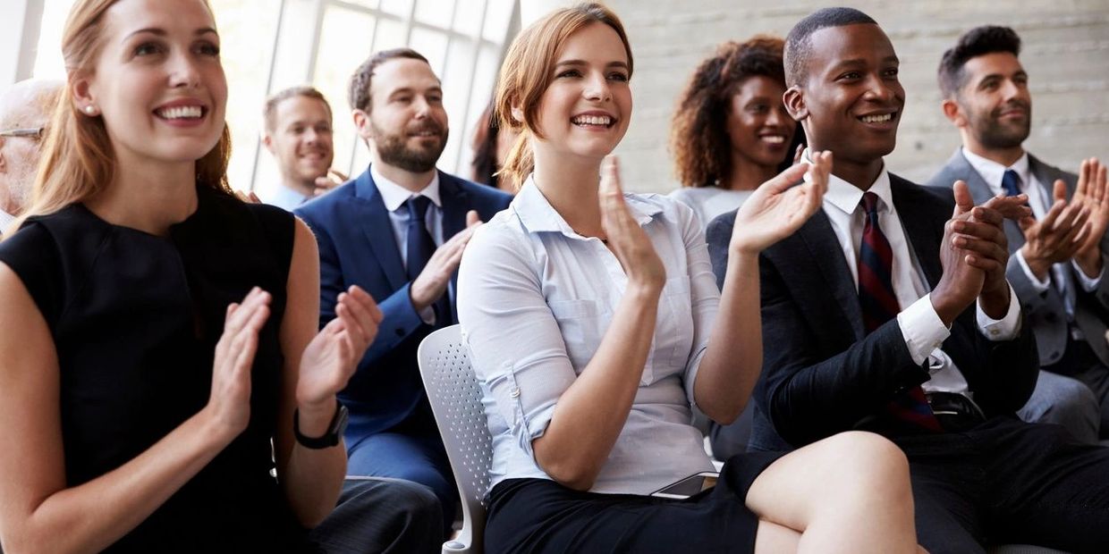 People are sitting on chair with clapping on hand and smiling