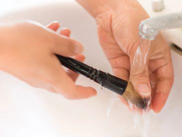 Cleaner washing a detailing brush