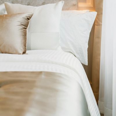 A neatly made bed with covers and pillows