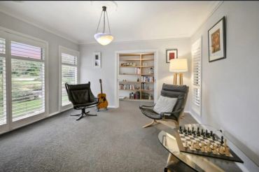 Minimalist sitting room with chairs and chessboard.