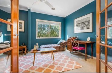 Cozy room with blue walls, wooden furniture, and a lounge chair.
