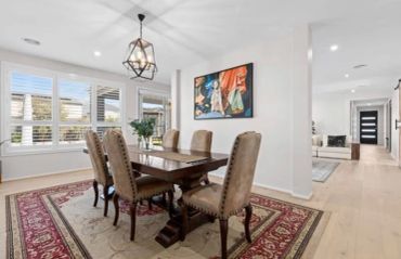 Elegant dining room with wooden table and upholstered chairs.