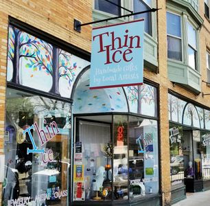 Store front colorful mural handpainted by local artist with vibrant window display