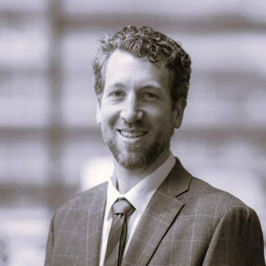 Professional man in suit smiling with blurred background.