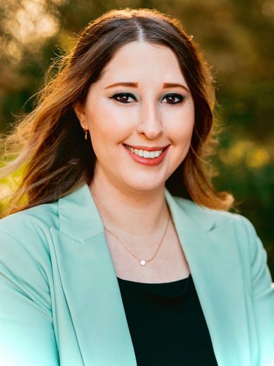 Woman standing outside wearing a black shirt and green jacket