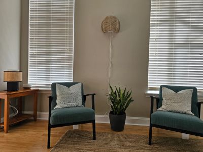 Cozy seating area with chairs, plant, and decor.