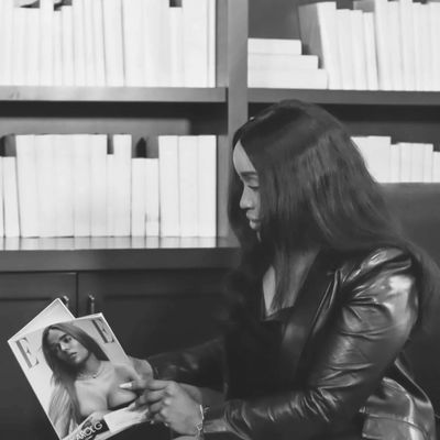 Woman reading a fashion magazine in a library.