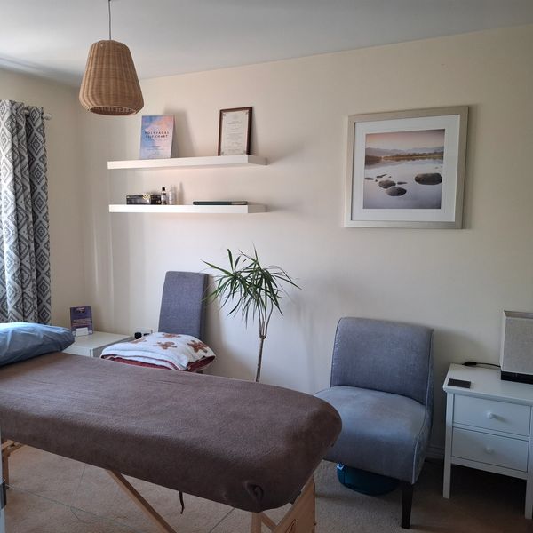 Cozy massage therapy room with a treatment table and relaxing decor.