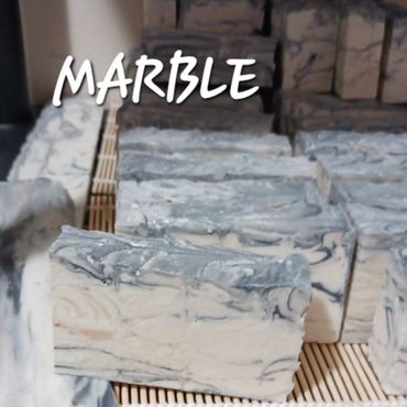 Handmade marble-patterned soap bars arranged on a mat.