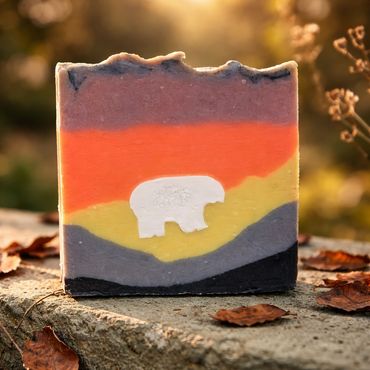 Colorful soap bar with a white bear design on a natural background.