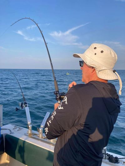 Action shot: Reeling in a big one on a fishing charter in Ashtabula, Ohio. Excitement guaranteed!