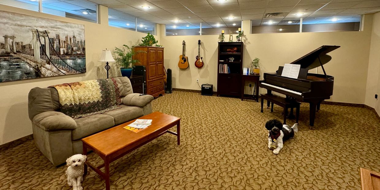 Experience Center in LHC includes baby grand piano, guitars, other instruments, sofa and plants