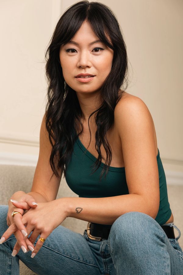 A woman sitting on the ground with her hands crossed.