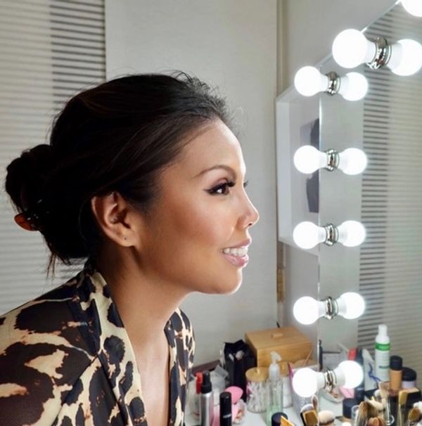 A woman is sitting in front of a mirror