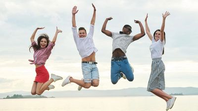 $ friends jumping at the beach