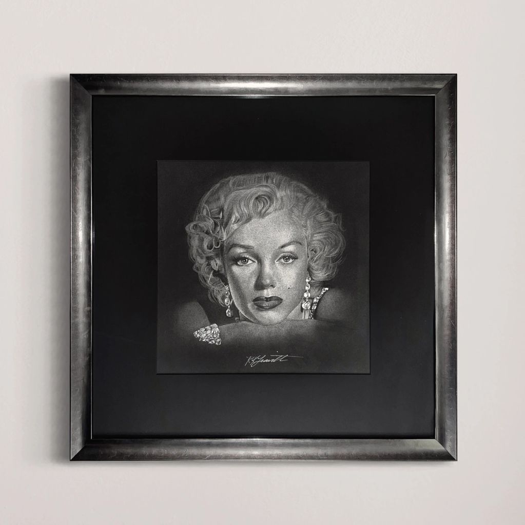 Black and white portrait of a woman with jewelry in a silver frame.