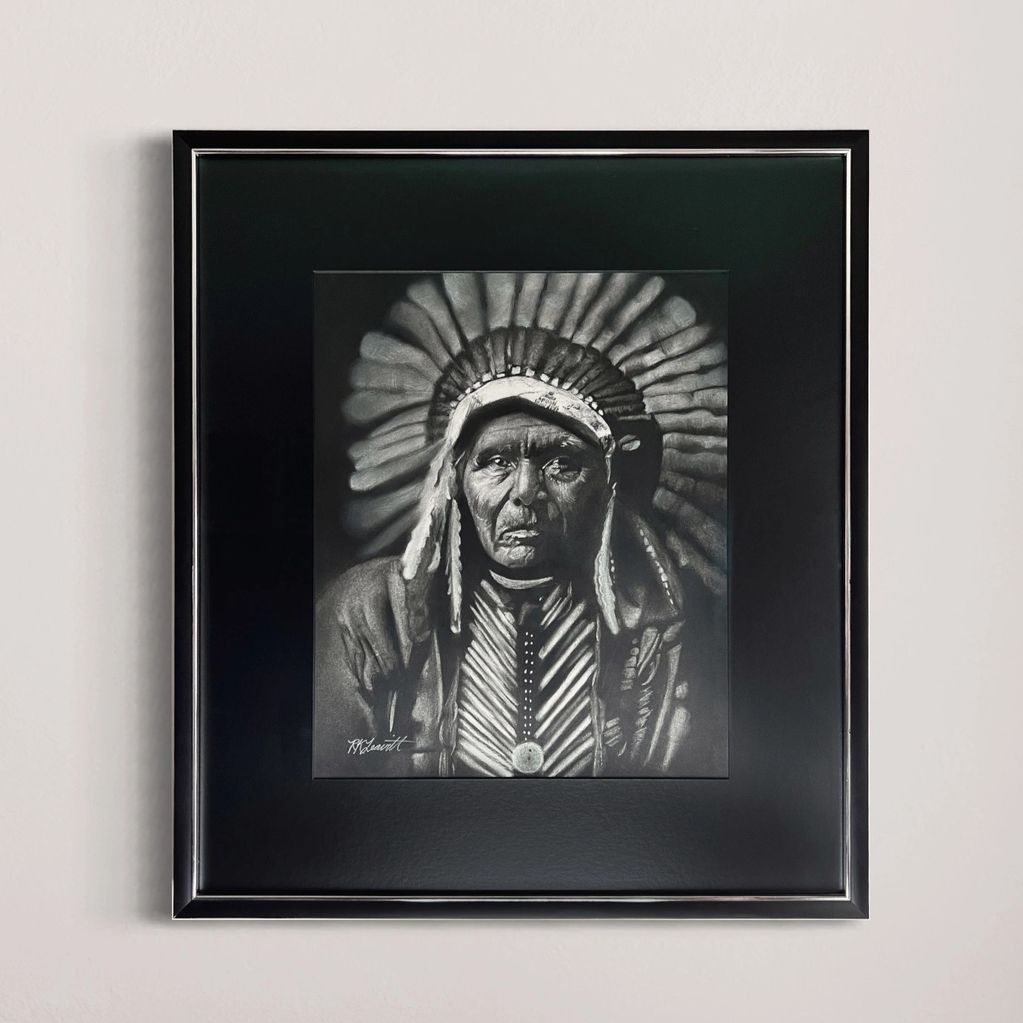 Framed black-and-white portrait of a Native American chief.