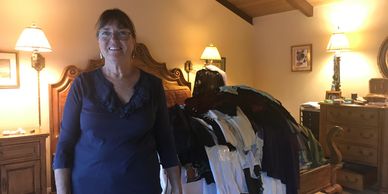 women posing in front of a pile of clothes