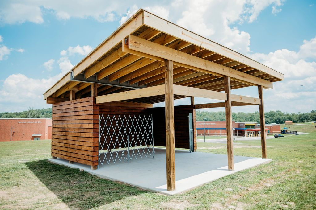 An outdoor classroom with a concrete flootr and timber framing.