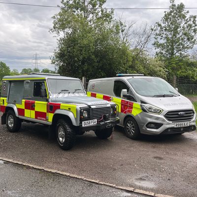 Two emergency vehicles parked side by side outdoors.