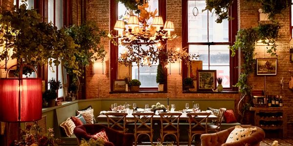 Cozy dining area with warm lighting, plants, and rustic decor.